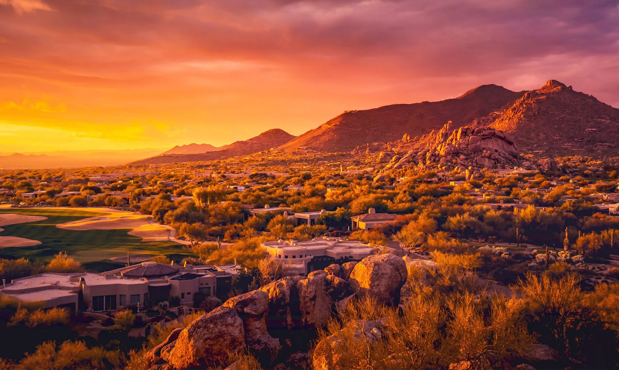 Sunset over the granite boulders, desert homes and fairways of North Scottsdale, Arizona